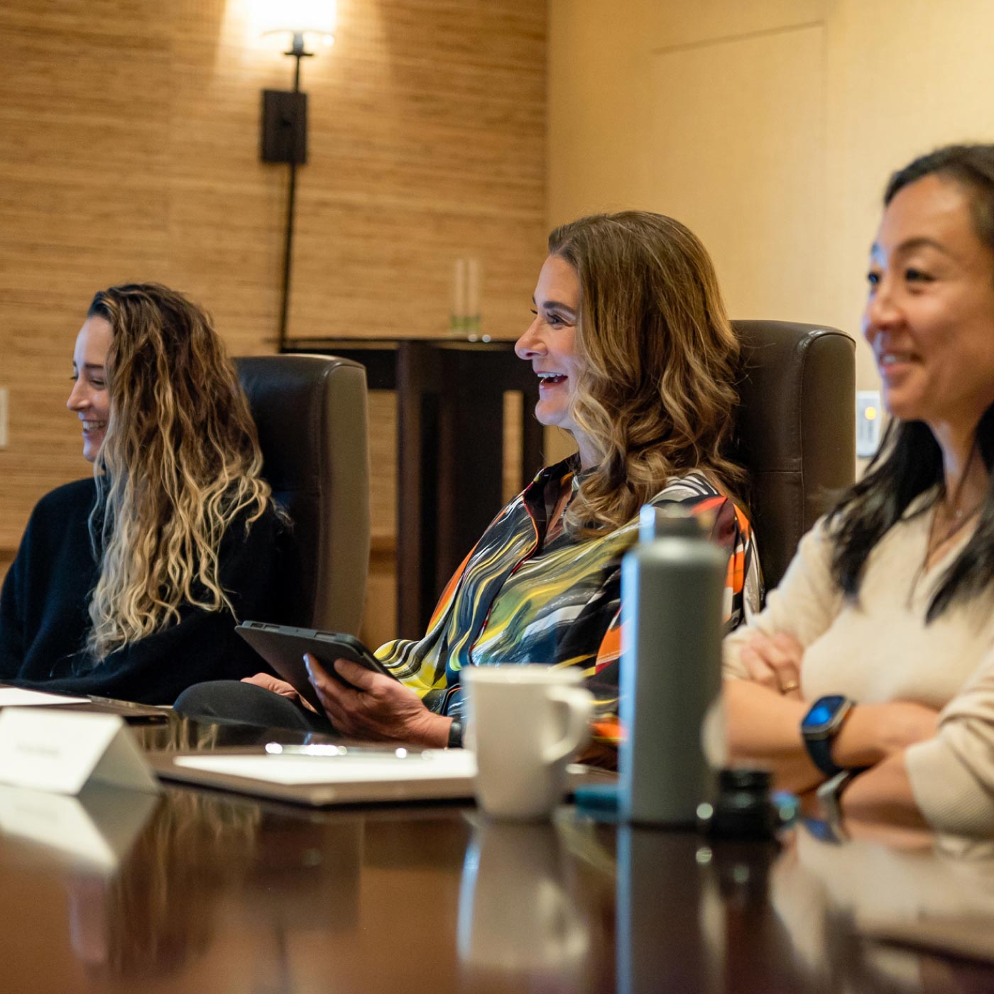 Three women sitting at a conference table.