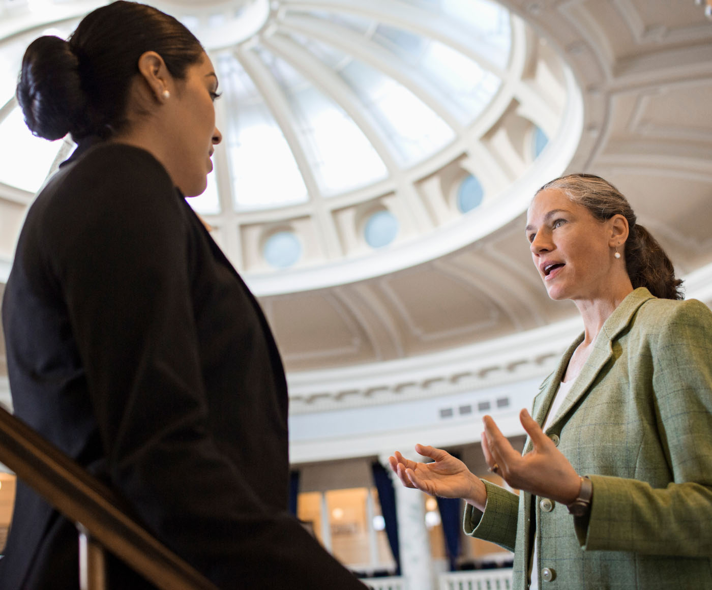 Two female politicians having a discussion in a capitol building
