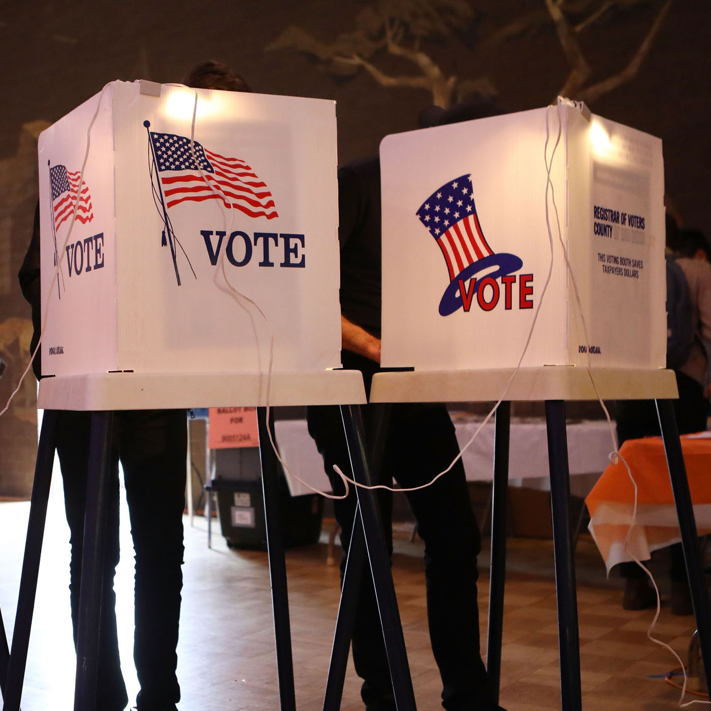 Three people voting at voting booths during a primary election