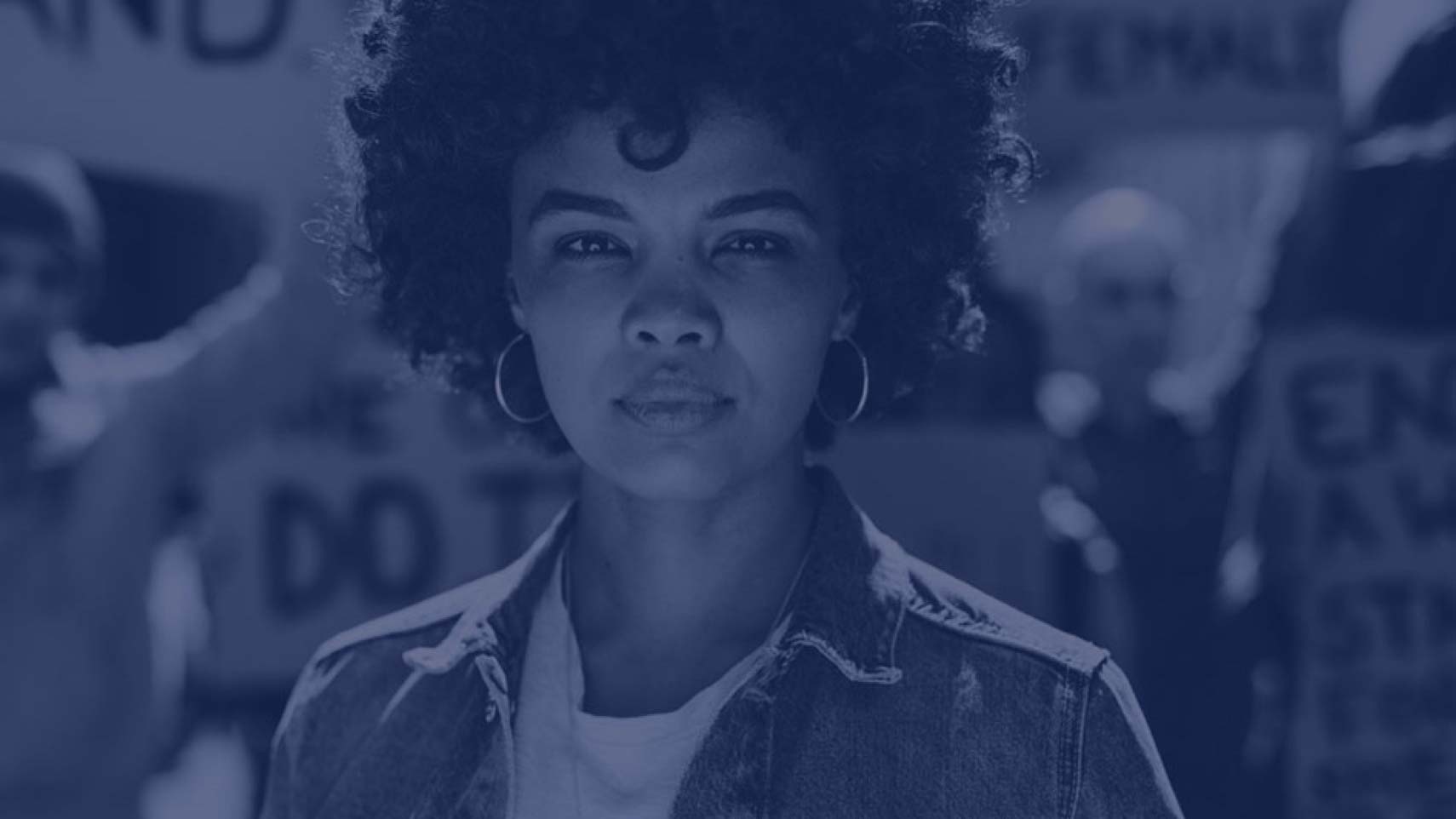 A person looks intensely into the camera in a blue-tinted photo.