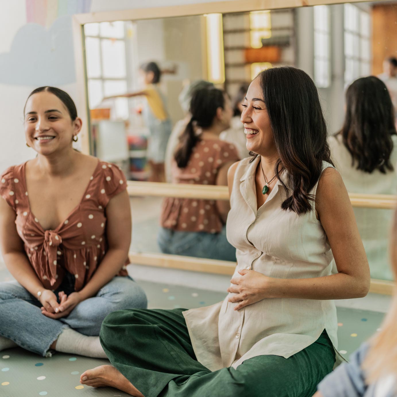A pregnant woman talks with other moms in a support group