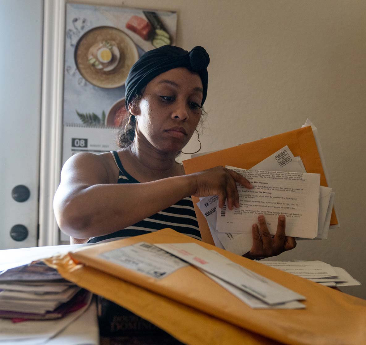 A 40-year-old woman sorts through a pile of mail.
