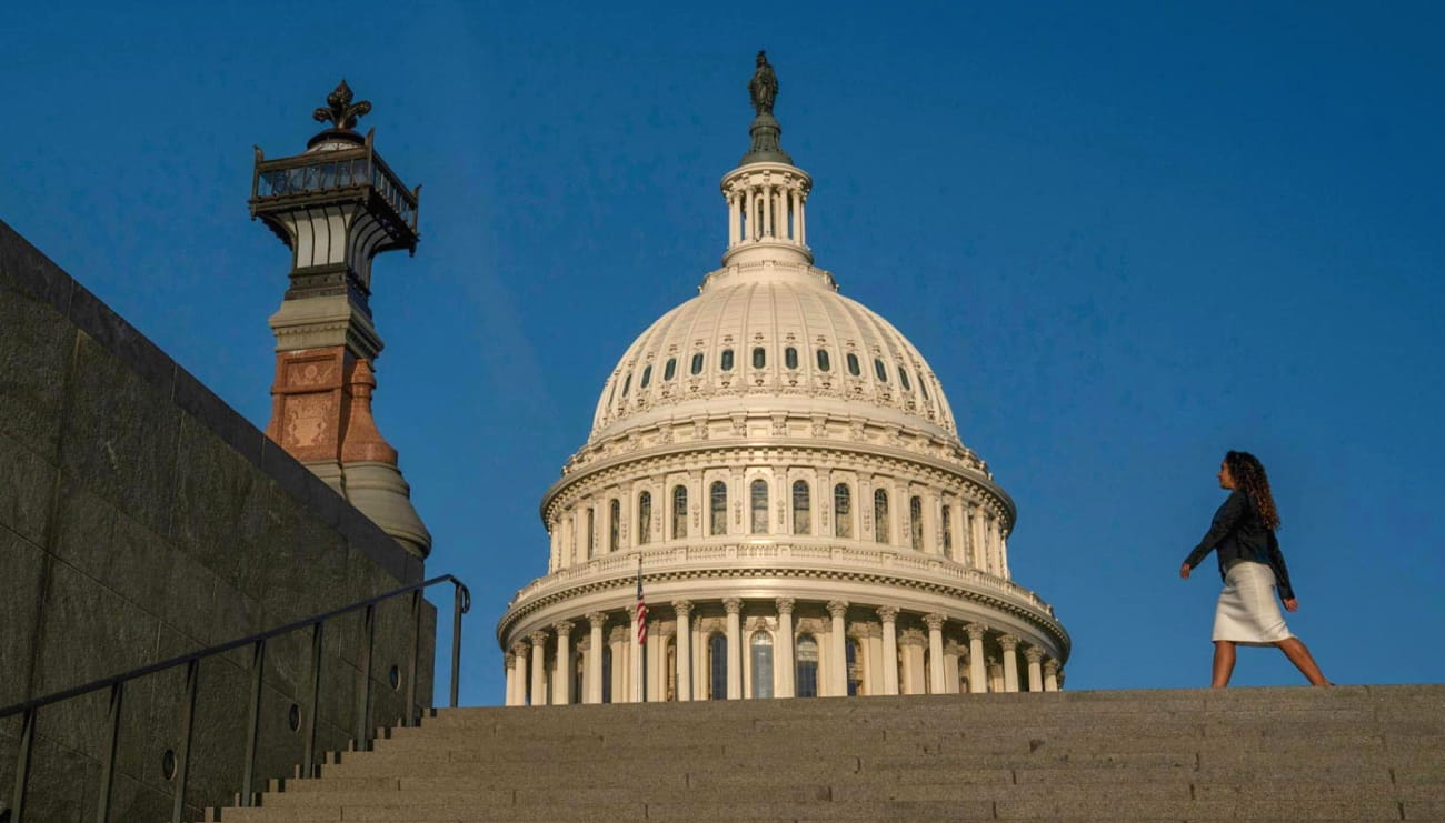 A woman walks in front of the Capitol building in Washington D.C.