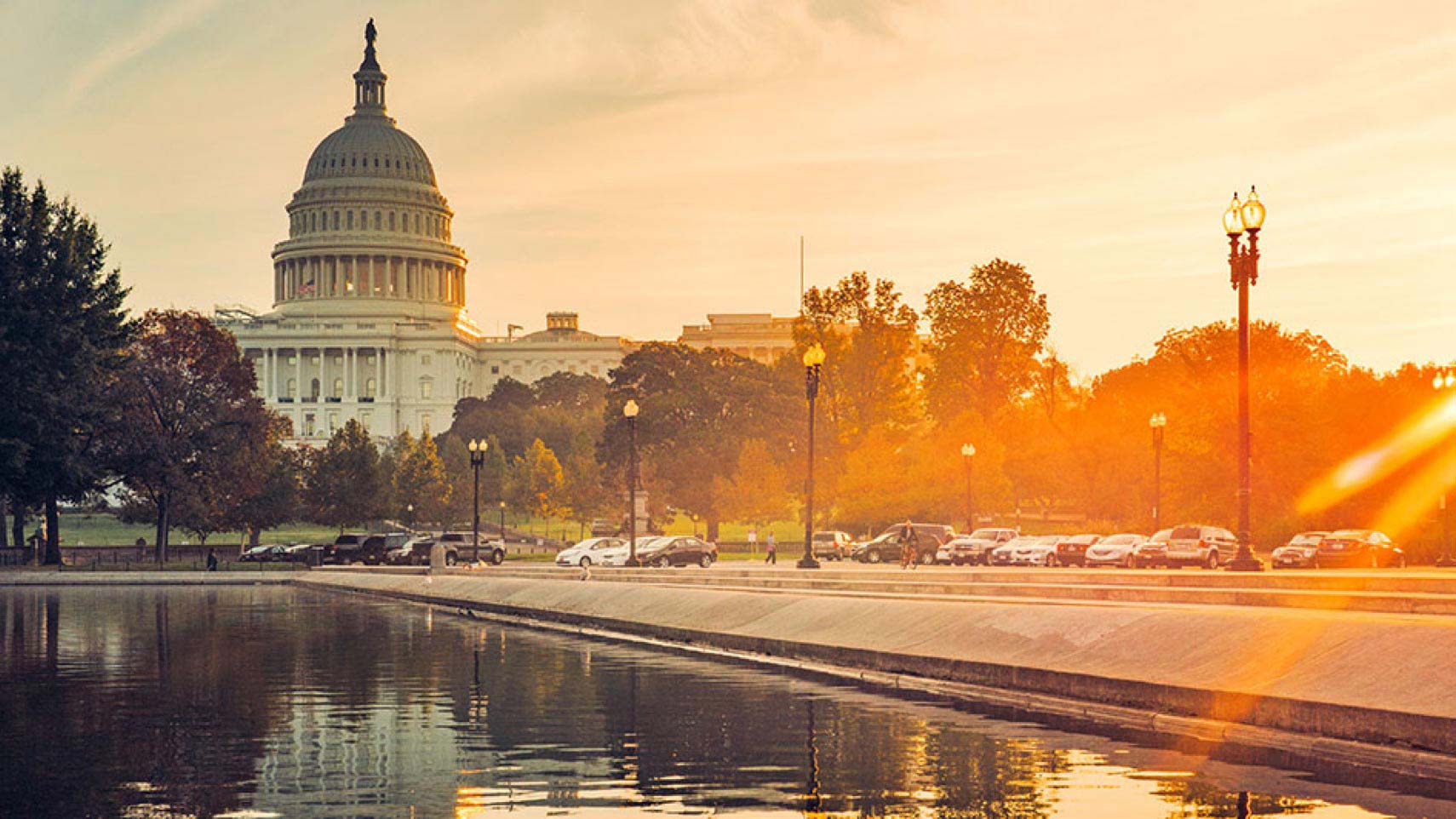 Golden light shines on the U.S. Capitol and the Capitol Reflecting Pool.