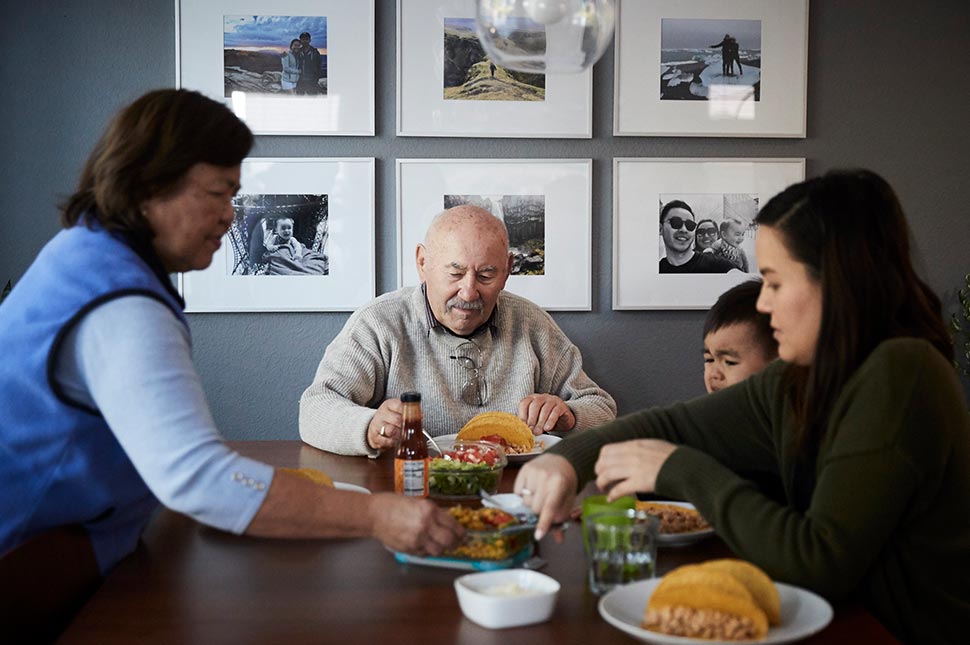 Analisa sits at the table eating dinner with her father and child