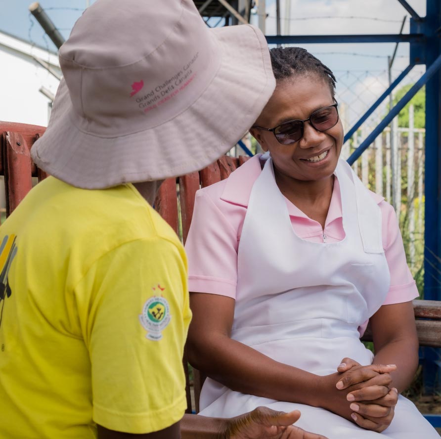 Two people have a conversation together on a bench.