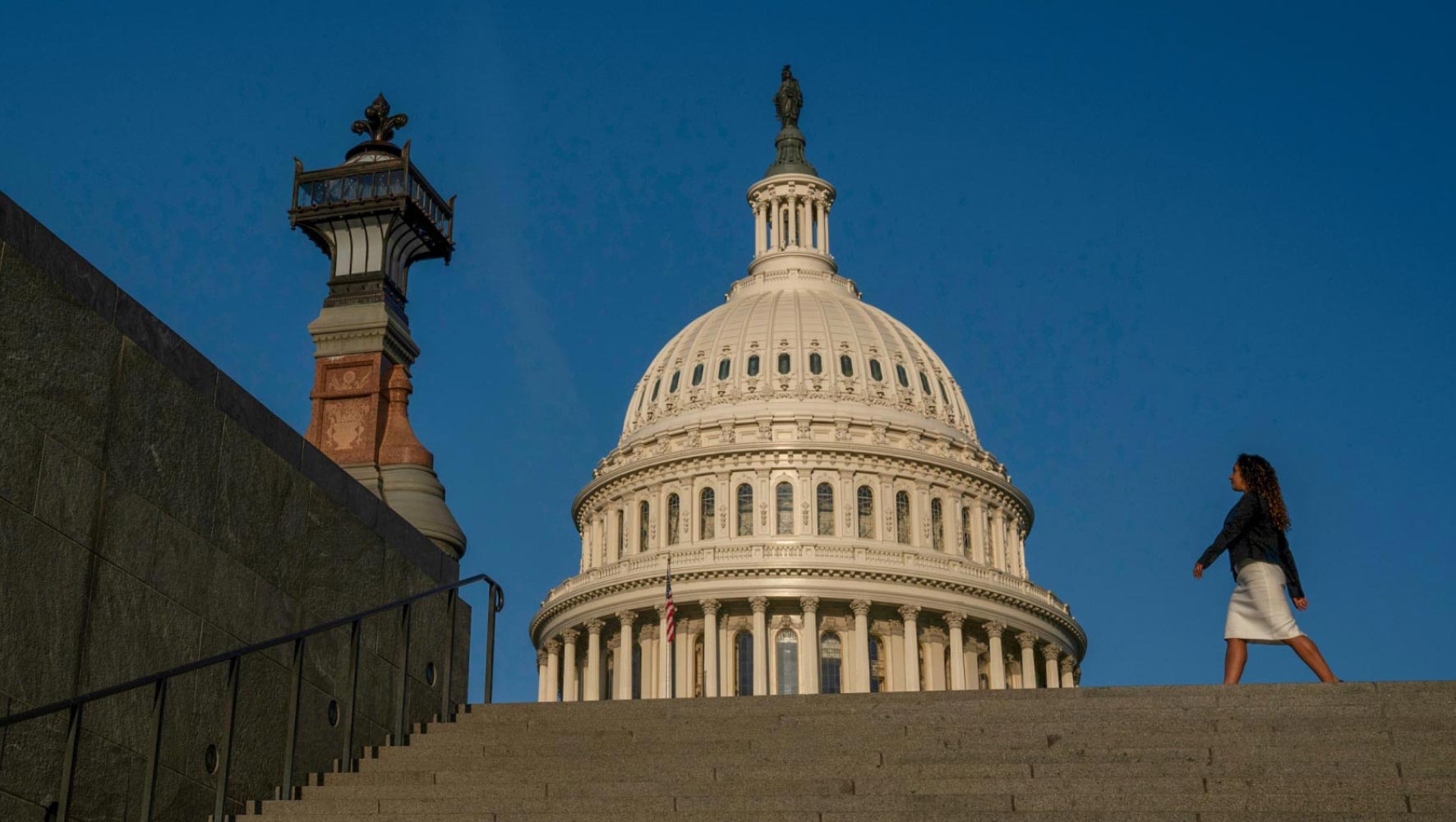 A woman walks in front of the Capitol building in Washington D.C.