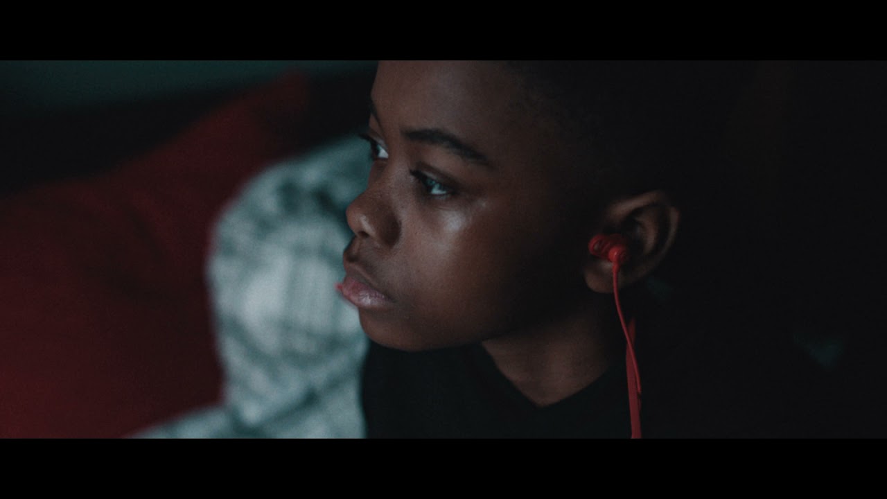 Thumbnail for a video featuring a young black boy listening to red haedphones.