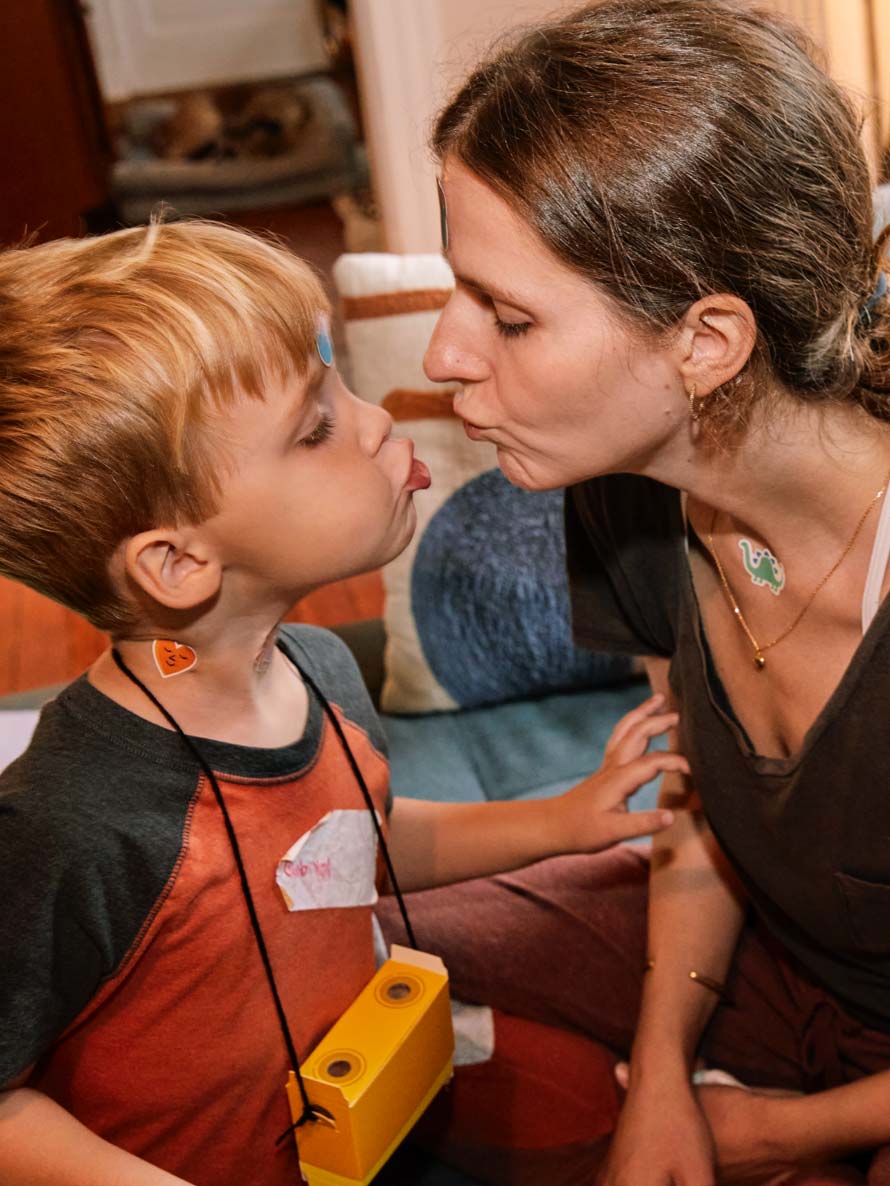A mother and her young son lean in to kiss each other.