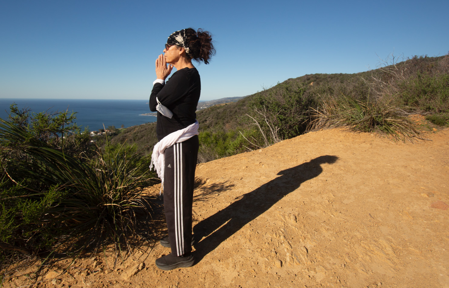 A person looks intensely into the camera in a blue-tinted photo.