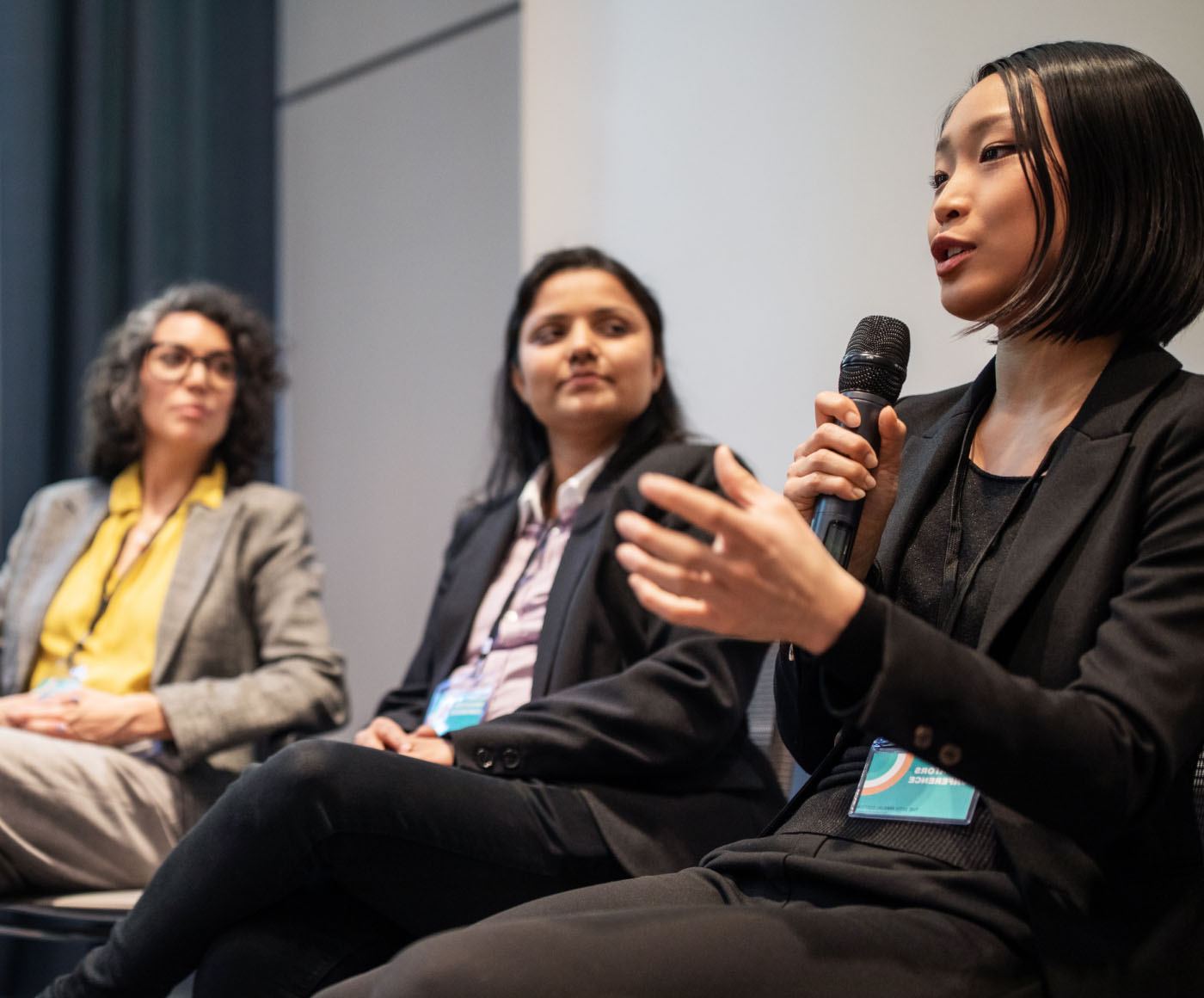 A woman speaks into a microphone on a panel