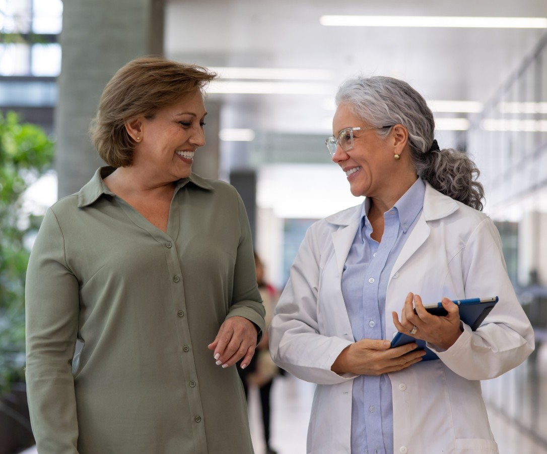 An older woman speaks with her doctor at the hospital.