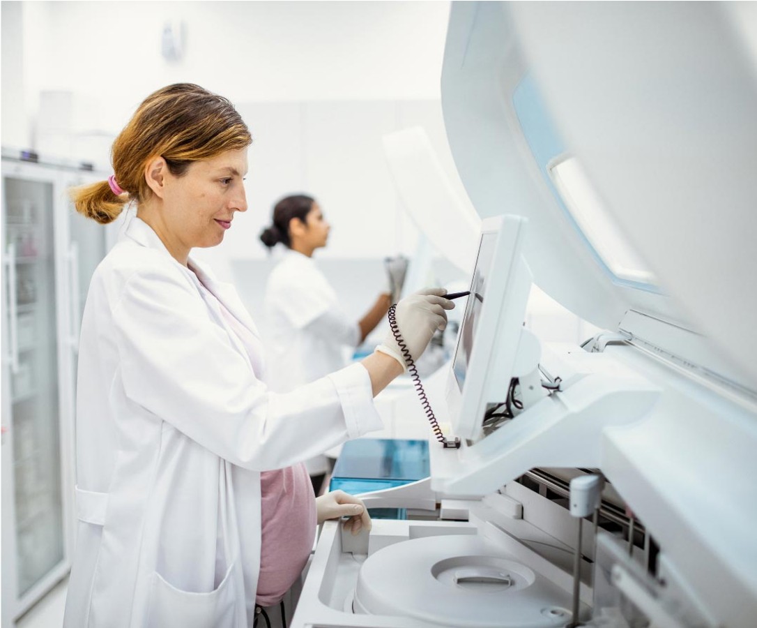 A female laboratory technician working with medical equipment.