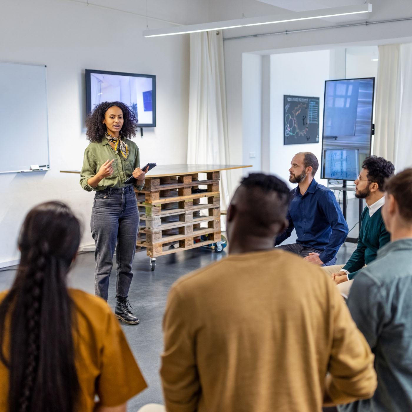 A startup entrepreneur leading a meeting with her team in a co-working office