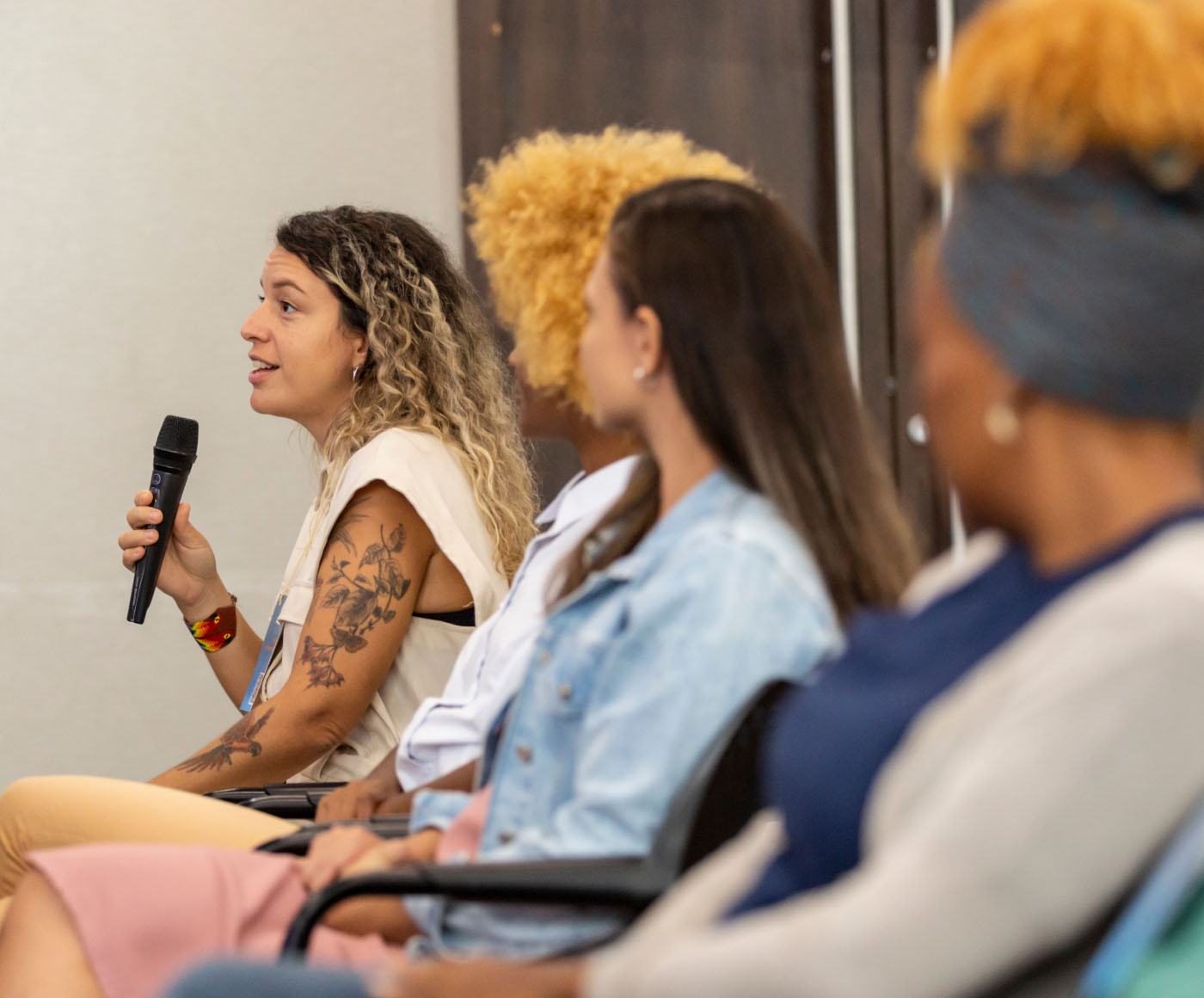 A young female audience member speaks into a microphone at an event