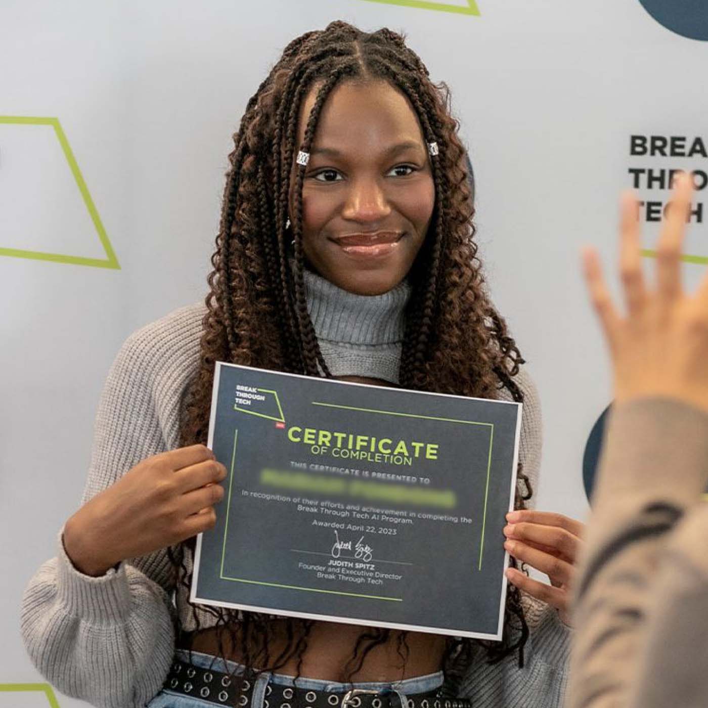 A teenager holding up a certificate of completion for an AI program