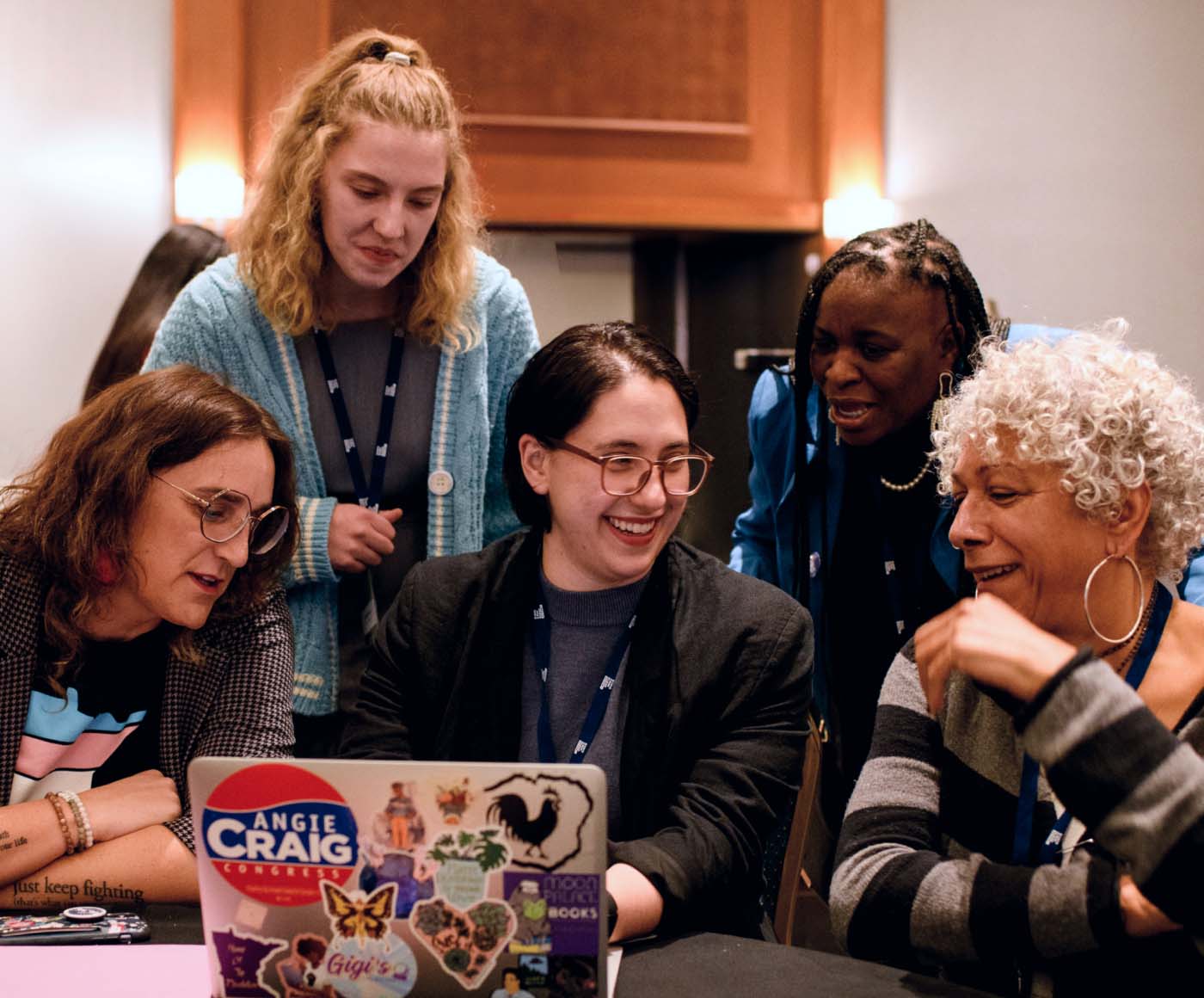Five women gathering around a laptop at a Vote Run Lead summit provided by Pivotal Ventures