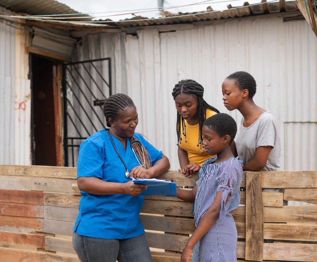A community nurse talks to three teenage girls about their health.