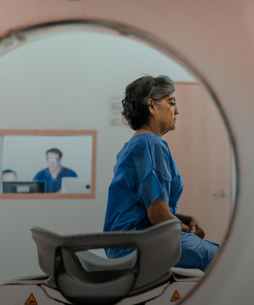 A woman is preparing for an MRI scan in a hospital.